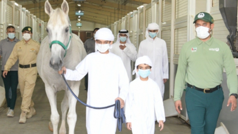 El niño emiratí y su hermano junto a un oficial de la Policía de Dubai. (Dubai Media Office)