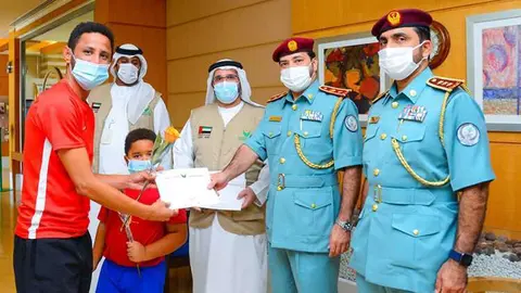 Funcionarios de la Policía de Sharjah con algunos de los afectados por el fraude. (Fuente externa)