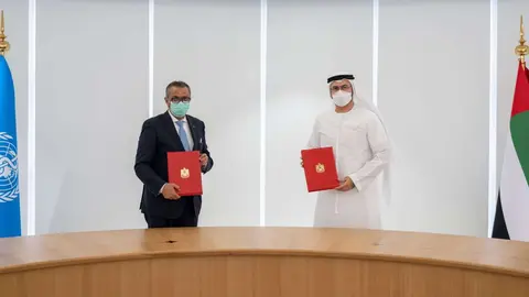 Un momento de la firma entre el ministro emiratí y el director de la OMS. (WAM)