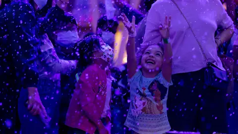Niños juegan con la nieve durante el encendido del árbol de Navidad de Al Wasl Plaza. (Expo Dubai 2020)