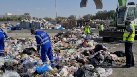 Los trabajadores de la gestión de residuos en Emiratos buscan la cartera. (Fuente externa)