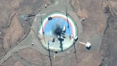 Foto satelital de Maxar Technologies, camiones y otros equipos rodean una plataforma de lanzamiento quemada en el puerto espacial Imam Khomeini de Irán. (AP)