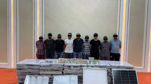 Los detenidos junto a la droga y los paneles solares. (Dubai Police)