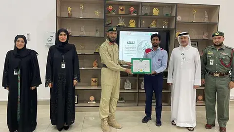 El taxista premiado con miembros de la Policía de Dubai.