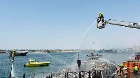 Miembros de Defensa Civil de Dubai apagan un incendio.