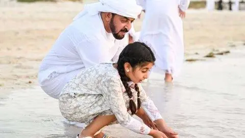 El jeque Hamdan bin Zayed  y una joven miembro de su familia liberan tortugas en Saadiyat Island. (Oficina de Medios de Abu Dhabi)