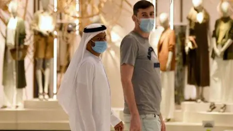 Dos clientes con mascarilla en un centro comercial de EAU. (Twitter)