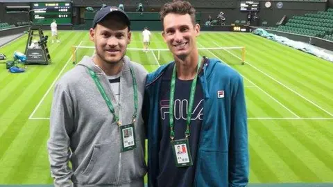El entrenador colombiano Ramírez (a la izquierda) junto al tenista Alexander Ritschard en la pista central de Wimbledon. (Cedida al diario The National)