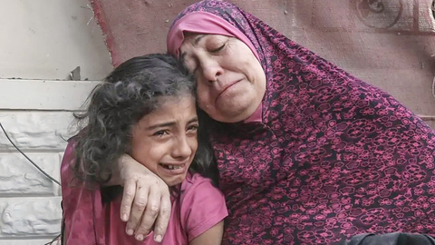 Una mujer palestina y su pequeña hija lloran por la destrucción de sus casa por bombardeo israelí en la Franja de Gaza. (@HoyPalestina)