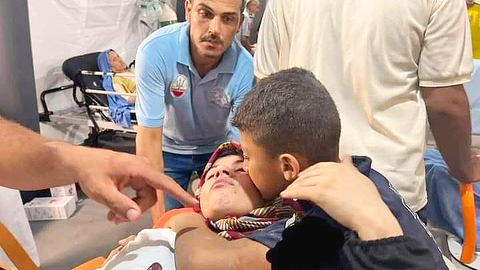 Niño palestino besa a su madre herida por un bombardeo israelí contra la localidad de Rafah al sur de Gaza. (Twitter)