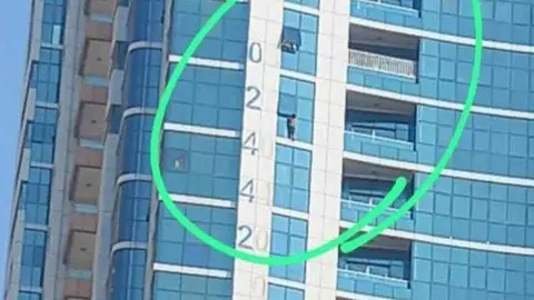 El niño en la ventana del edificio en Sharjah. (Fuente externa)