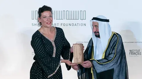 El jeque Sultan bin Muhammad Al Qasimi entrega el galardón a la chilena Catherine Mazoyer. (WAM)