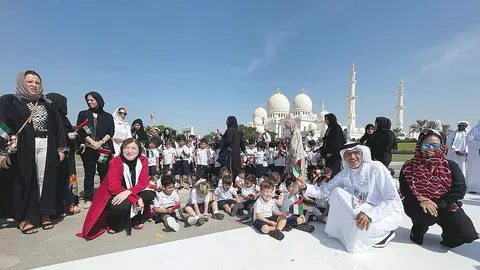 Alumnos de The Spanish School of Abu Dhabi, junto al director general de la Gran Mezquita del Jeque Zayed y a la directora del colegio, entre otros asistentes al Día de la Bandera que el colegio protagonizó en la Gran Mezquita del jeque Zayed. (EL CORREO)