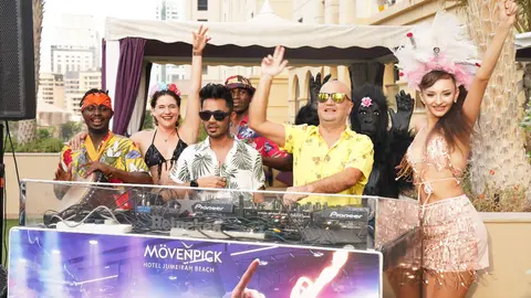 David Saludes -segundo por la derecha-, a todo ritmo junto a bailarinas, 'drummlers' y la mazcota de 'Tropicana Lovers' en el área exterior de piscina de Movenpick JBR. (EL CORREO)