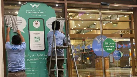 Trabajadores retiran las etiquetas de Al Hosn en un centro comercial de Abu Dhabi. (Fuente externa)