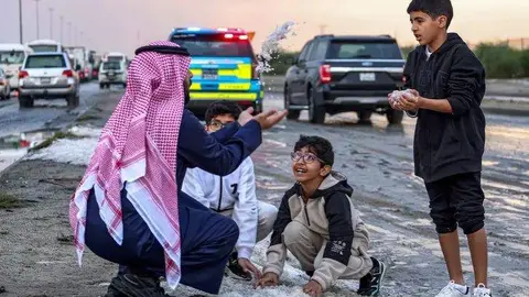 Kuwaitíes juegan con el granizo caído en diciembre de 2022. (Fuente externa)
