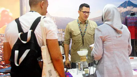 Raúl Rodas, campeón mundial de baristas, atiende a los visitantes en el stand de Guatemala en World of Coffee Dubai 2023. (EL CORREO)
