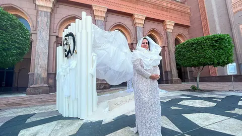 La artista sevillana Mercedes Eirín en el Emirates Palace de Abu Dhabi ante su obra 'Las dunas infinitas' vestida con un modelo de la diseñadora andaluza Susana Álvarez. (EL CORREO)