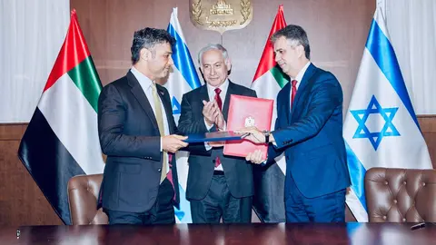 Un momento de la firma del pacto de libre comercio entre el embajador emiratí en Israel (izquierda) y el ministro de Exteriores israelí. (Twitter)