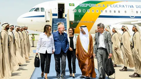 El presidente brasileño recibido por el ministro de Energía de Emiratos en el aeropuerto de Abu Dhabi. (WAM)