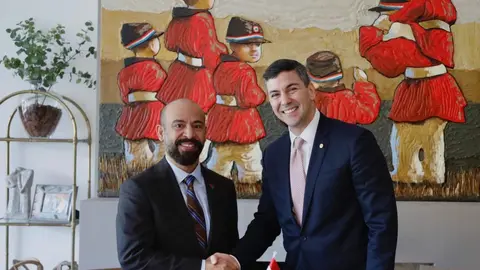 El embajador emiratí (izquierda) estrecha la mano del presidente electo de Paraguay. (WAM)