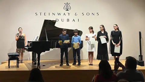 María del Rosario Sierra, junto a sus alumnos sobre el escenario de House of Pianos Al Qouz en Dubai. (EL CORREO)