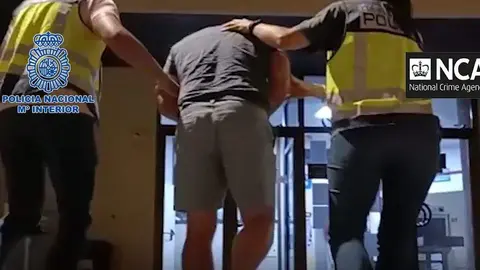 El detenido junto a dos policías españoles. (Policía Nacional de España)