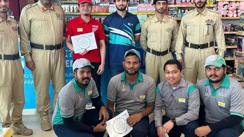 Los trabajadores de la gasolinera de Enoc junto a oficiales de la Policía de Dubai. (Twitter)