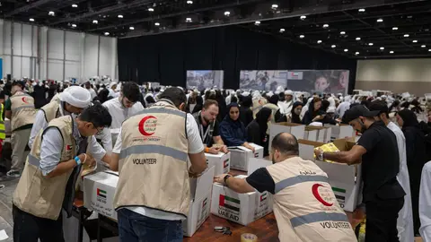 Voluntarios empacan la ayuda en la campaña “Tarahum - for Gaza” de Emiratos. (WAM)