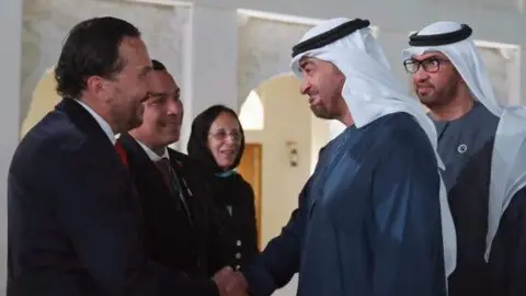 El presidente de EAU saluda al ministro venezolano, Lorca Vega, ante el diplomático Samir Al Attrach. (Cedida)