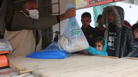 Voluntarios de Emiratos Árabes entregan ayuda alimentaria en Gaza. (WAM)