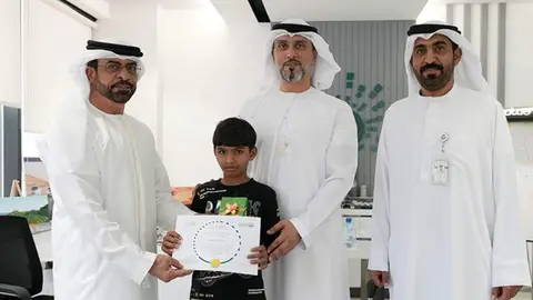 El menor posa con el reconocimiento recibido. (Dubai Police)