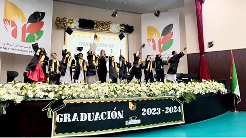 Los alumnos de sexto de primaria de The Spanish School of Abu Dhabi lanzan sus birretes al aíre. (EL CORREO)