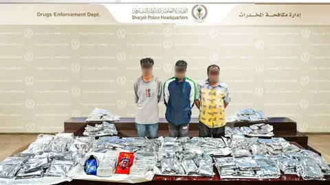 Los contrabandistas junto a las drogas incautadas. (Policía de Sharjah)