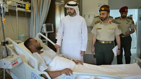 El príncipe heredero de Dubai y ministro de Defensa visita a uno de los militares heridos en el accidente. (WAM)