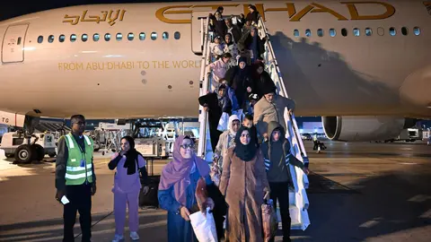 Los evacuados de Gaza descienden del avión en Abu Dhabi. (WAM)