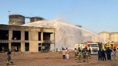 Bomberos apagan el incendio en el puerto de Sharjah. (WAM)