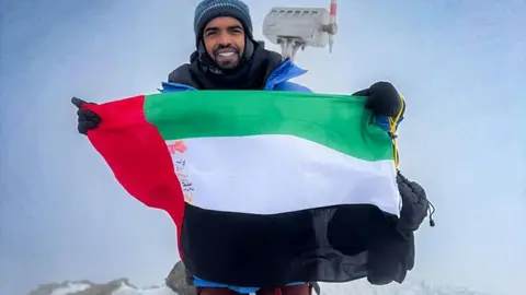 El aventurero emiratí Rashid Ghanem Al Shamsi, con la bandera de Emiratos Árabes Unidos en la cima del monte Elbrus. (WAM)