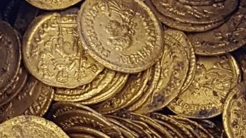 Una imagen de X de monedas de oro. (X)