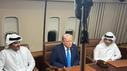 El presidente de Estados Unidos, Donald Trump -en el centro-, durante la reunión con el emir de Qatar, Tamim bin Hamad Al Thani  -izquierda- y su primer ministro, Mohammed bin Abdulrahman Al Thani, este sábado en Qatar a bordo del Air Force One. (Pool)