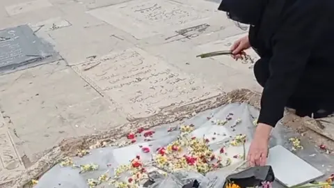 Una mujer deposita flores en el lugar de la muerte de un joven en Teher&aacute;n. (X)