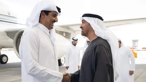 El presidente de EAU (derecha) saluda al emir de Qatar. (WAM)