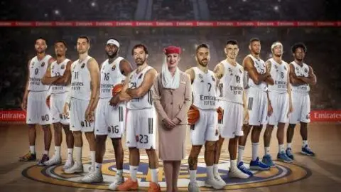 Una tripulante de cabina de Emirates posa con el equipo del Real Madrid. (Emirates)