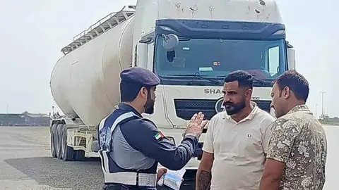 Un polic&iacute;a de Abu Dhabi junto a camioneros. (Instagram)
