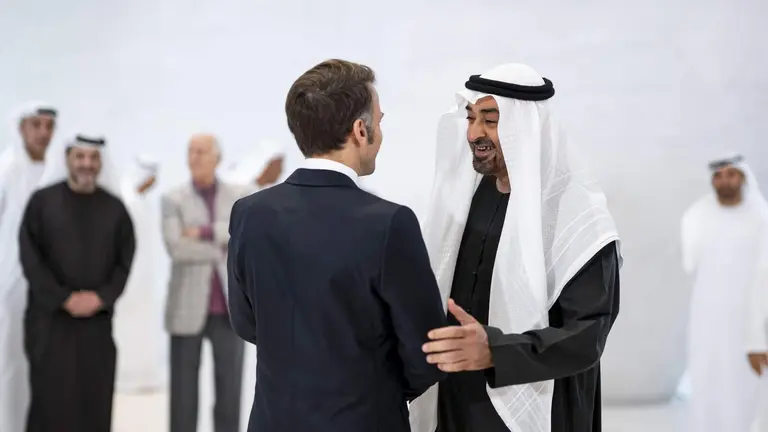El presidente de EAU saluda a Macron en Abu Dhabi. (WAM)