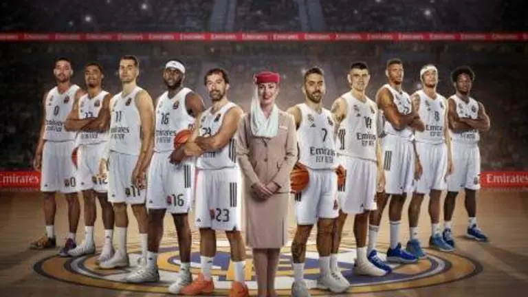 Una tripulante de cabina de Emirates posa con el equipo del Real Madrid. (Emirates)