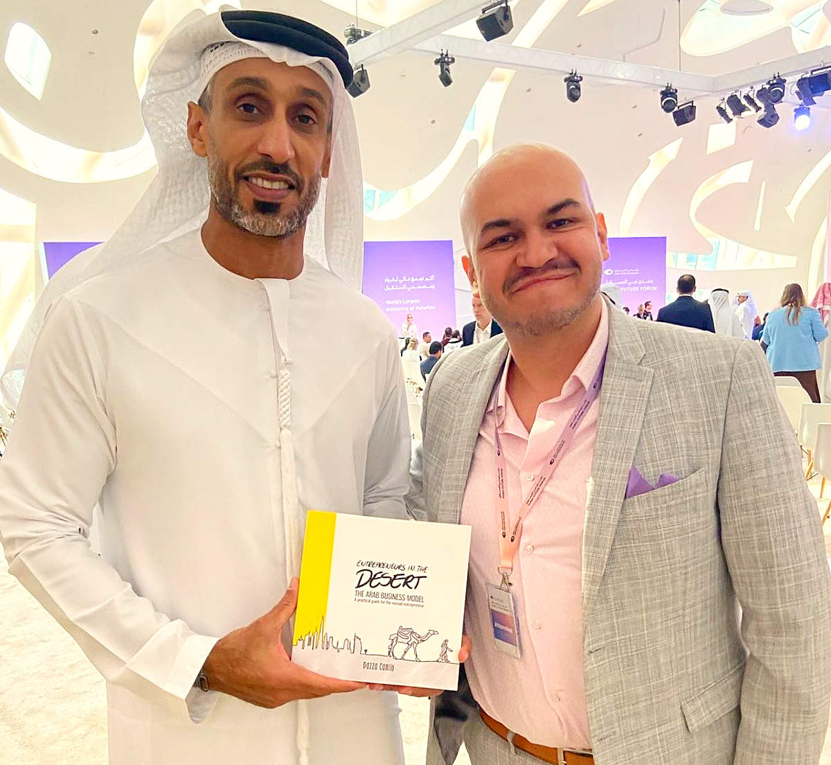 Invitado a Dubai Future Forum -izquierda- muestra el libro 'Emprender en el desierto' de Camilo Dazza, quien aparece en la imagen junto a él y es el autor del texto de este artículo. (Cedida)