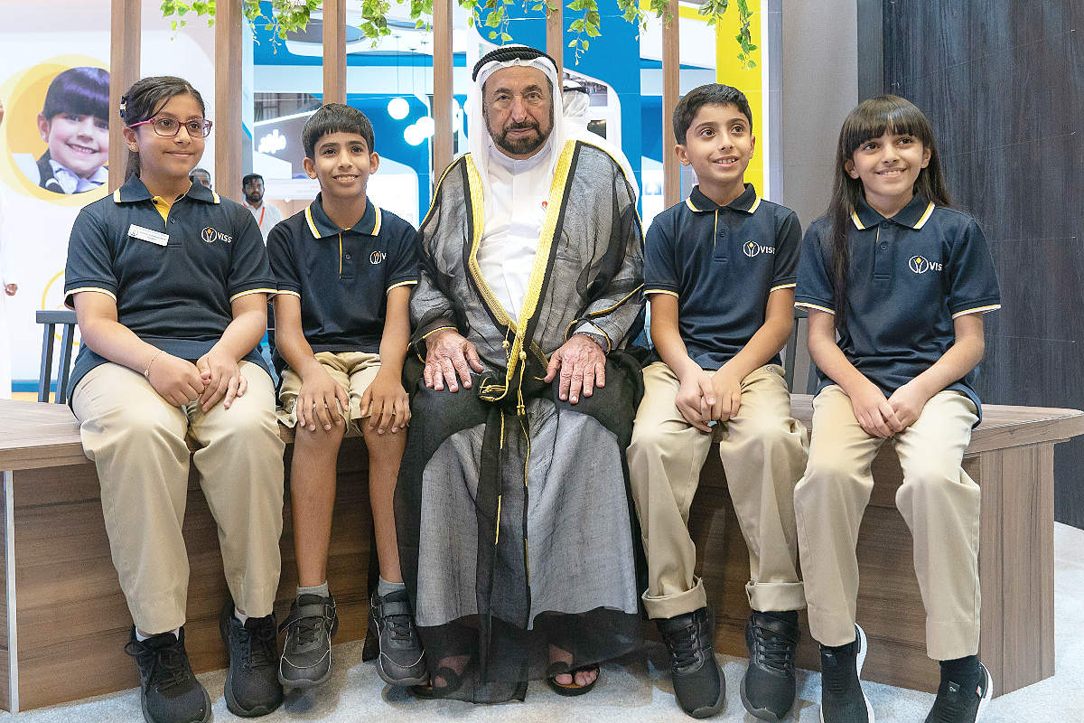 El jeque Sultán bin Muhammad Al Qasimi posa con un grupo de niños, base del futuro del árabe. (WAM)