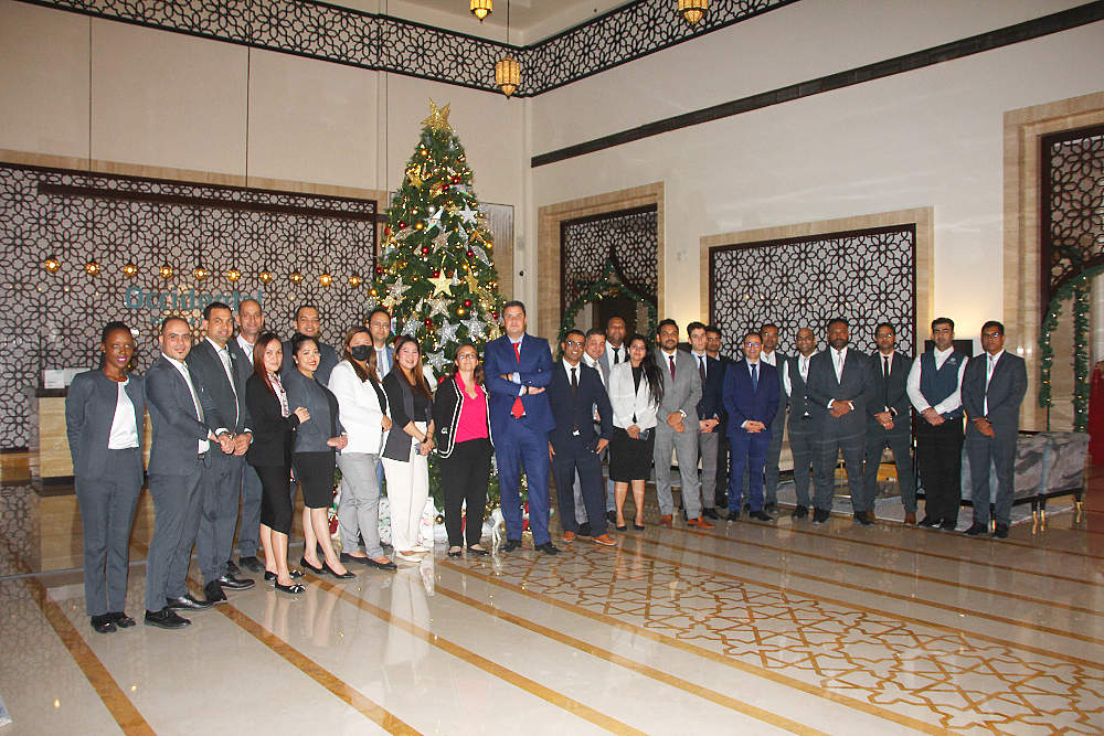 El personal del hotel Occidental Al Jaddaf, ante el árbol de Navidad tras ser iluminado. (EL CORREO)