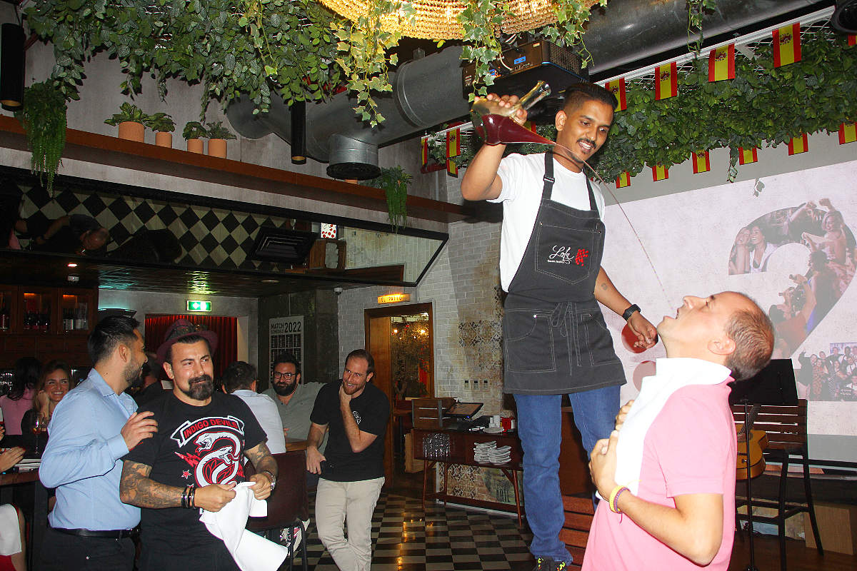 Bebiendo a chorro del porrón en el segundo aniversario de Lola Taberna. (EL CORREO)